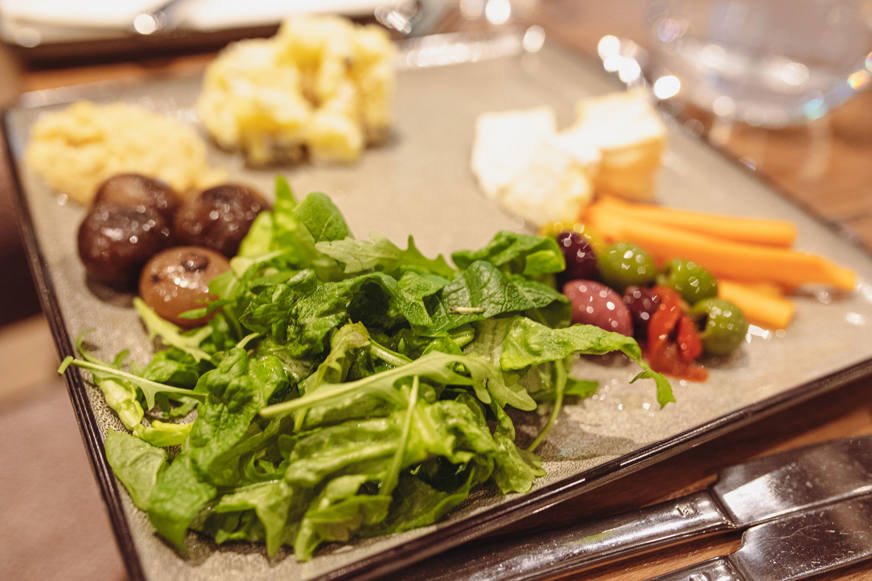 olives and rocket and carrots on a plate