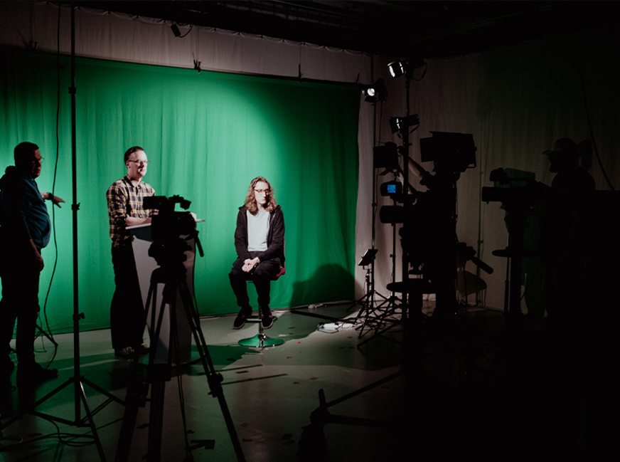 students on stage being interviewed with camera set up