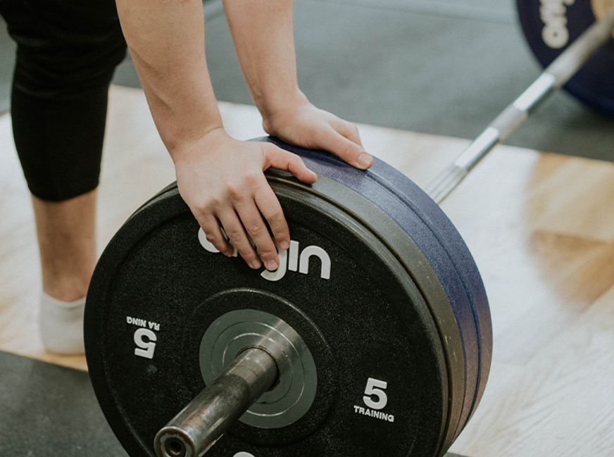 close up of someones hand changing weight on bar
