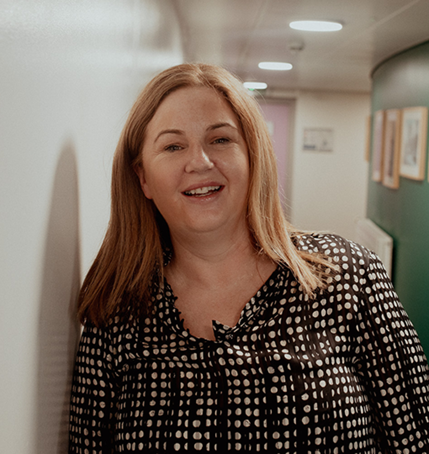 female student smiling at camera in corridor