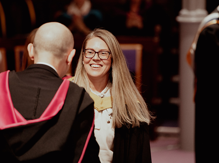 graduate shaking hands with principal on stage