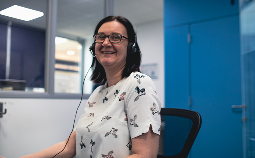 reception staff member smiling at camera wearing headset