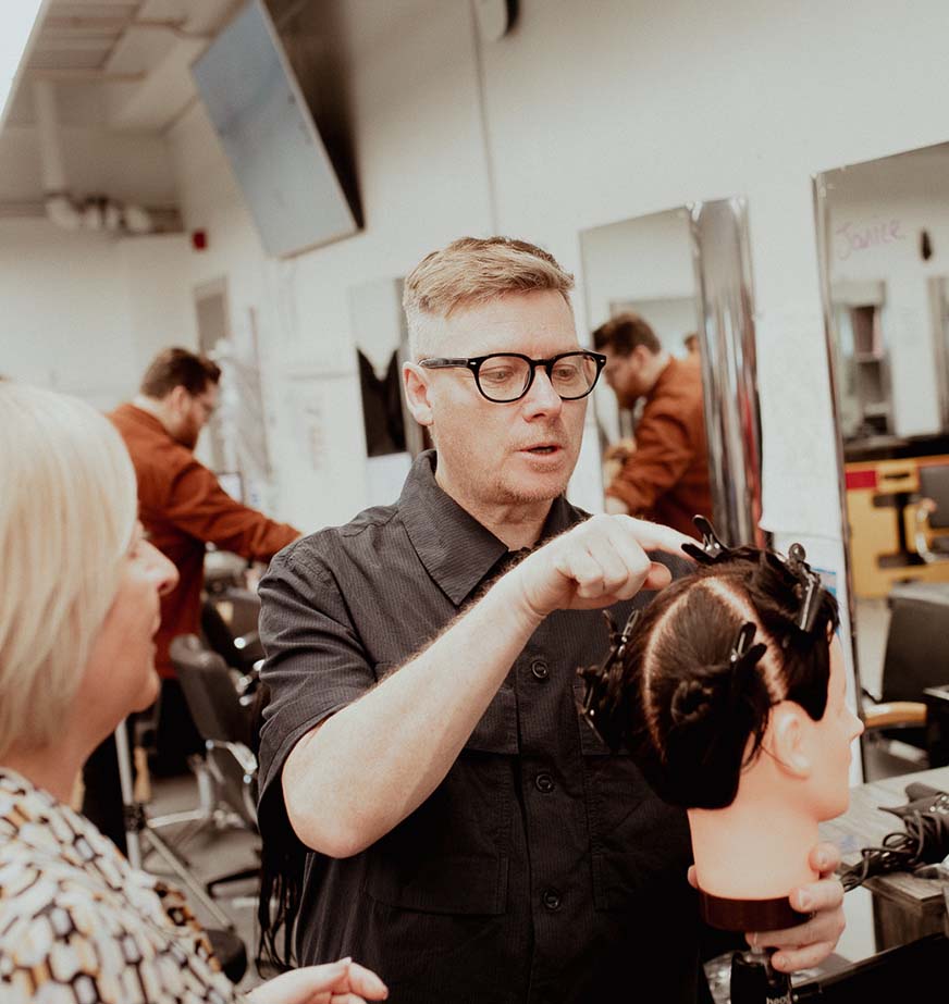 hairdresser cutting hair on dummy