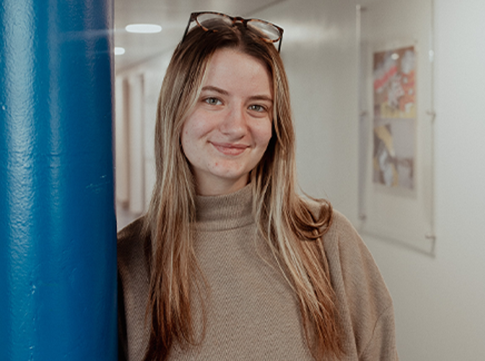 girl leaning on pillar smiling at camera