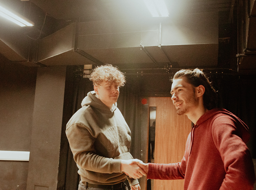 male drama students smiling in class